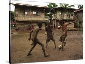 A Group of Panamanian Youths Slide Through the Mud During a Pick-Up Game of Soccer-null-Stretched Canvas