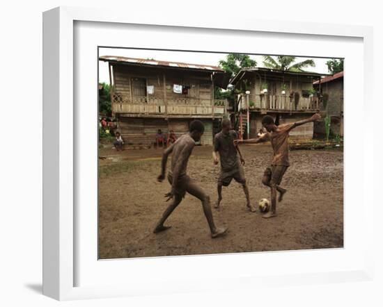 A Group of Panamanian Youths Slide Through the Mud During a Pick-Up Game of Soccer-null-Framed Premium Photographic Print