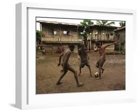 A Group of Panamanian Youths Slide Through the Mud During a Pick-Up Game of Soccer-null-Framed Premium Photographic Print