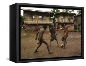 A Group of Panamanian Youths Slide Through the Mud During a Pick-Up Game of Soccer-null-Framed Stretched Canvas