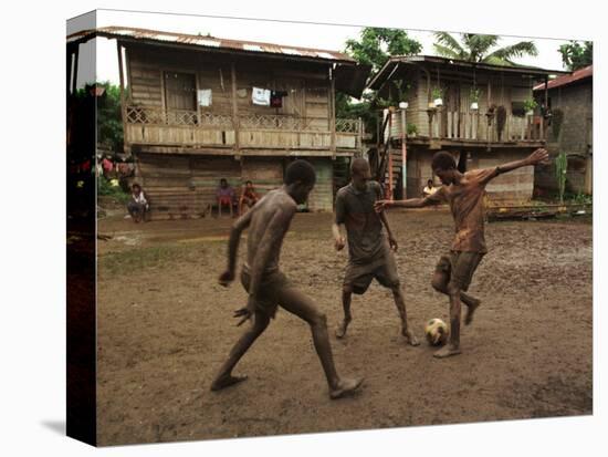 A Group of Panamanian Youths Slide Through the Mud During a Pick-Up Game of Soccer-null-Stretched Canvas