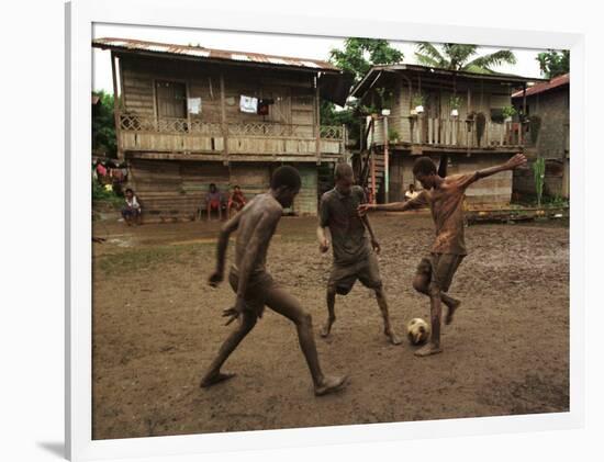 A Group of Panamanian Youths Slide Through the Mud During a Pick-Up Game of Soccer-null-Framed Photographic Print