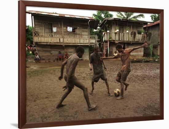 A Group of Panamanian Youths Slide Through the Mud During a Pick-Up Game of Soccer-null-Framed Photographic Print