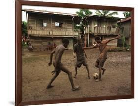A Group of Panamanian Youths Slide Through the Mud During a Pick-Up Game of Soccer-null-Framed Photographic Print