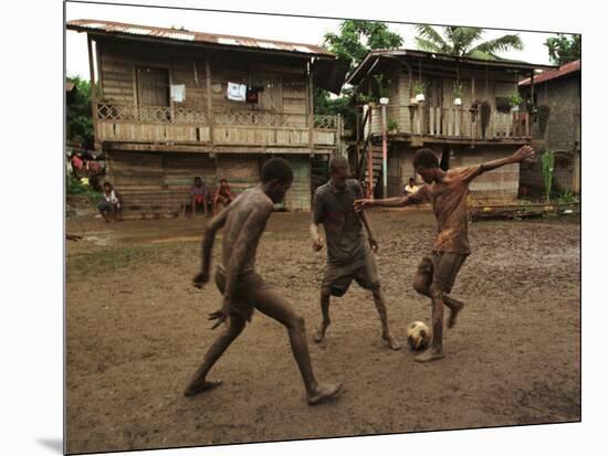 A Group of Panamanian Youths Slide Through the Mud During a Pick-Up Game of Soccer-null-Mounted Photographic Print