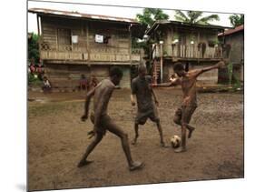 A Group of Panamanian Youths Slide Through the Mud During a Pick-Up Game of Soccer-null-Mounted Photographic Print