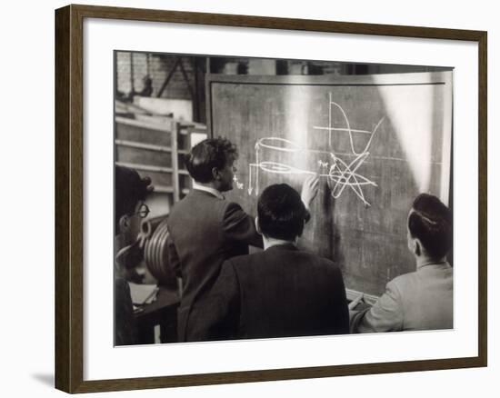 A Group of Scientists Study a Problem by Using Diagrams on a Blackboard-Henry Grant-Framed Photographic Print