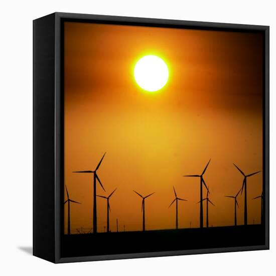 A Group of Wind Turbines are Silhouetted by the Setting Sun-Charlie Riedel-Framed Stretched Canvas