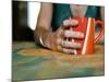 A Hand Holding a Red Mug-Katrin Adam-Mounted Photographic Print