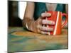 A Hand Holding a Red Mug-Katrin Adam-Mounted Photographic Print