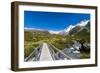 A hiking trail crosses wooden bridge over a creak high up in the mountains, New Zealand-Logan Brown-Framed Photographic Print