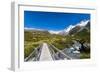 A hiking trail crosses wooden bridge over a creak high up in the mountains, New Zealand-Logan Brown-Framed Photographic Print