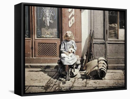 A Little Girl Playing with Her Doll; Two Guns and a Knapsack are Next to He-Fernand Cuville-Framed Stretched Canvas