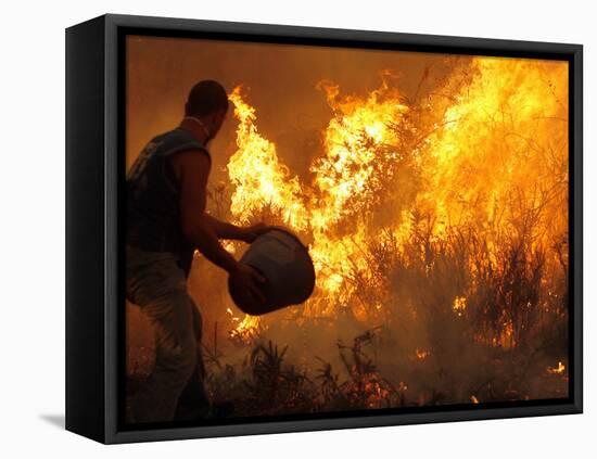 A Local Resident Throws a Bucket of Water on a Forest Fire-null-Framed Stretched Canvas