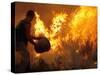 A Local Resident Throws a Bucket of Water on a Forest Fire-null-Stretched Canvas