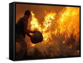 A Local Resident Throws a Bucket of Water on a Forest Fire-null-Framed Stretched Canvas