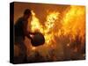 A Local Resident Throws a Bucket of Water on a Forest Fire-null-Stretched Canvas