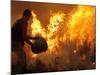 A Local Resident Throws a Bucket of Water on a Forest Fire-null-Mounted Photographic Print
