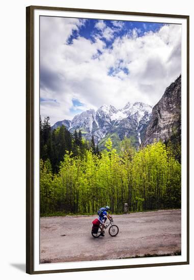 A Lone Cyclist Travels Along a Mountain Road with Trees and the Julian Alps in the Background-Sean Cooper-Framed Premium Photographic Print