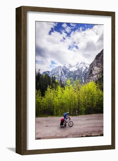 A Lone Cyclist Travels Along a Mountain Road with Trees and the Julian Alps in the Background-Sean Cooper-Framed Photographic Print