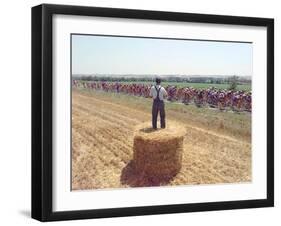 A Lone Spectator Watches the Pack Ride by from the Top of a Bale of Hay-null-Framed Photographic Print