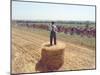 A Lone Spectator Watches the Pack Ride by from the Top of a Bale of Hay-null-Mounted Photographic Print