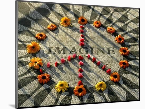 A Makeshift Peace Sign of Flowers Lies on Top John Lennon's Strawberry Fields Memorial-null-Mounted Photographic Print