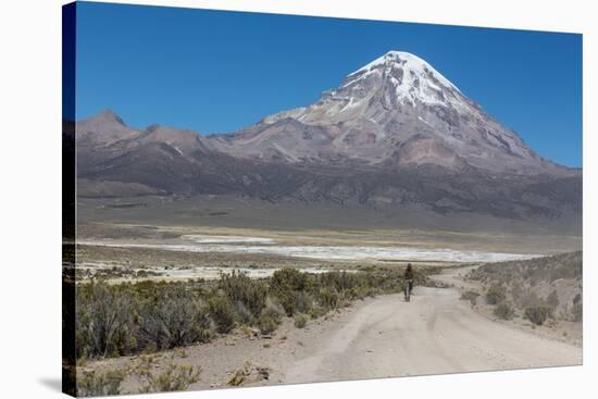 A Man Cycles in the Shadow of Sajama Volcano in Sajama National Park-Alex Saberi-Stretched Canvas