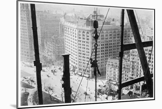 A Man Hangs Precariously from a Line During the Construction of a Skyscraper in New York-null-Mounted Photographic Print