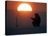 A Man Icefishes on the Frozen Finnish Gulf at Sunset Outside St.Petersburg-null-Stretched Canvas
