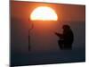 A Man Icefishes on the Frozen Finnish Gulf at Sunset Outside St.Petersburg-null-Mounted Photographic Print