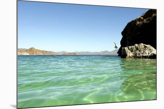 A Man Jumps into a Bay Near Loreto, Baja Sur, Mexico-Bennett Barthelemy-Mounted Photographic Print