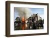 A Man Makes His Way Out of Flood Waters as Fire Burns Down a Home-Shannon Stapleton-Framed Photographic Print