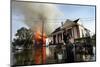 A Man Makes His Way Out of Flood Waters as Fire Burns Down a Home-Shannon Stapleton-Mounted Photographic Print