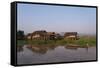 A man paddles his canoe past one of the floating villages on Inle Lake, Myanmar (Burma), Asia-Alex Treadway-Framed Stretched Canvas