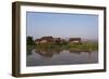 A man paddles his canoe past one of the floating villages on Inle Lake, Myanmar (Burma), Asia-Alex Treadway-Framed Photographic Print