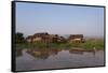 A man paddles his canoe past one of the floating villages on Inle Lake, Myanmar (Burma), Asia-Alex Treadway-Framed Stretched Canvas