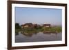 A man paddles his canoe past one of the floating villages on Inle Lake, Myanmar (Burma), Asia-Alex Treadway-Framed Photographic Print