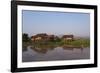 A man paddles his canoe past one of the floating villages on Inle Lake, Myanmar (Burma), Asia-Alex Treadway-Framed Photographic Print