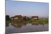 A man paddles his canoe past one of the floating villages on Inle Lake, Myanmar (Burma), Asia-Alex Treadway-Mounted Photographic Print