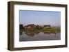 A man paddles his canoe past one of the floating villages on Inle Lake, Myanmar (Burma), Asia-Alex Treadway-Framed Photographic Print