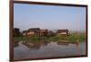 A man paddles his canoe past one of the floating villages on Inle Lake, Myanmar (Burma), Asia-Alex Treadway-Framed Photographic Print