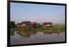 A man paddles his canoe past one of the floating villages on Inle Lake, Myanmar (Burma), Asia-Alex Treadway-Framed Photographic Print