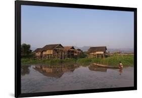 A man paddles his canoe past one of the floating villages on Inle Lake, Myanmar (Burma), Asia-Alex Treadway-Framed Photographic Print