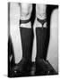 A Man Using "Sock Suspenders" to Hold Up His Socks; in America They are Called Garters-null-Stretched Canvas