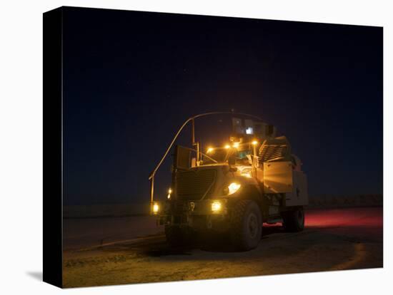 A Maxxpro MRAP Vehicle with Running Lights on at Night-null-Stretched Canvas