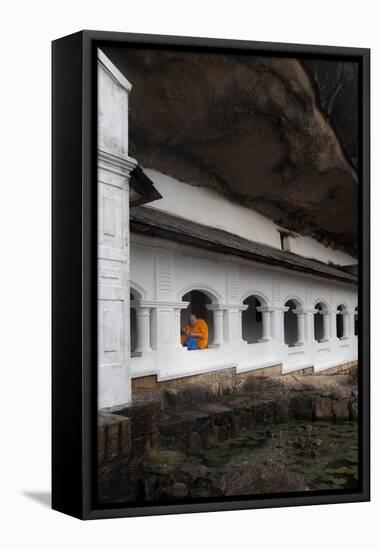 A Monk Sits and Looks at His Phone Beneath Shelter-Charlie-Framed Stretched Canvas