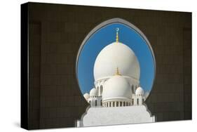 A mosque is framed by an arched passageway in Abu Dhabi, United Arab Emirates, Middle East-Logan Brown-Stretched Canvas