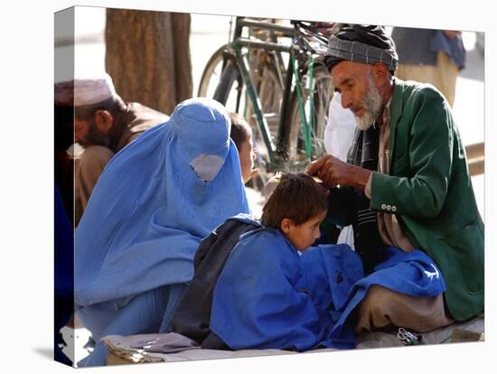 A Mother Watches as Her Child Gets a Haircut in the Center of Kabul, Afghanistan on Oct. 9, 2003.-null-Stretched Canvas