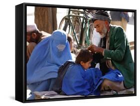 A Mother Watches as Her Child Gets a Haircut in the Center of Kabul, Afghanistan on Oct. 9, 2003.-null-Framed Stretched Canvas